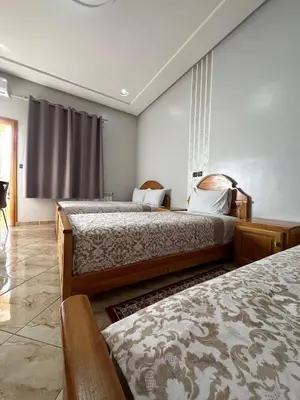 a hotel room with two beds and a window at Hôtel Imilchil in Midelt