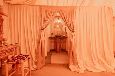 a room with white curtains and a table and a mirror at Imperial Glory Lodges in Merzouga