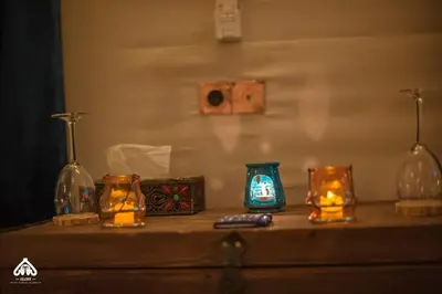 a table with candles and glass bottles on it at Imperial Glory Lodges in Merzouga