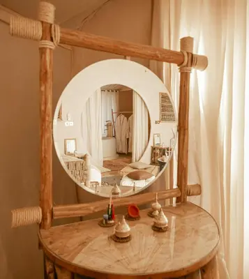 a round mirror on top of a wooden table at Imperial Glory Lodges in Merzouga