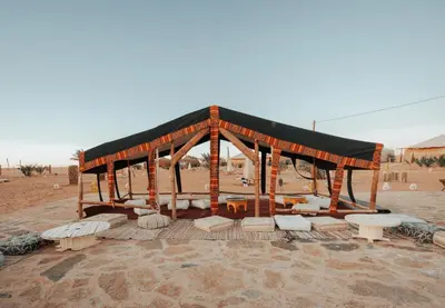 a wooden pavilion in the middle of the desert at Imperial Glory Lodges in Merzouga