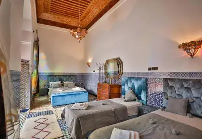 a large room with two beds and a tub at Riad Dar Jeanne in Fès
