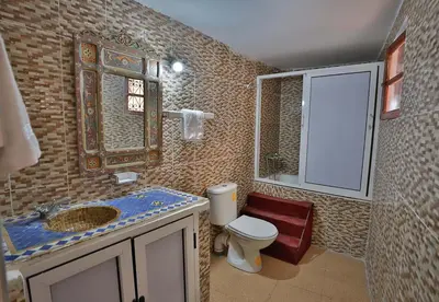 a bathroom with a toilet and a sink and a mirror at Riad Dar Jeanne in Fès
