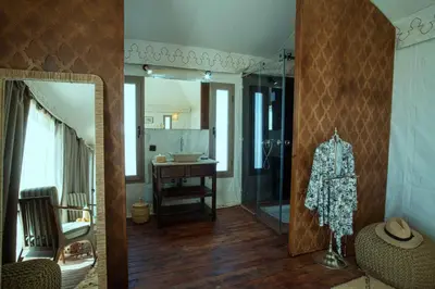 a bathroom with a walk in shower and a mirror at Ghazala Camp - Luxury Erg Chigaga Magic in Mhamid