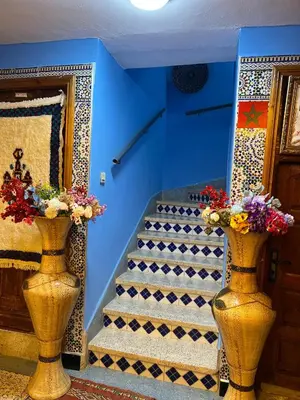 two vases with flowers in them next to a staircase at Motel Ain Mersa in Ifrane