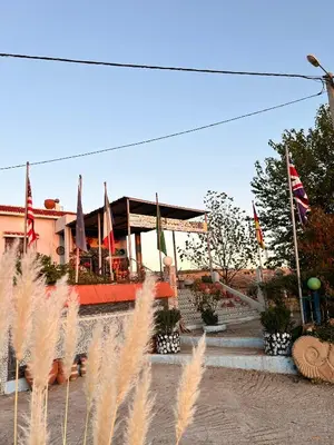 a building with flags and plants in front of it at Motel Ain Mersa in Ifrane