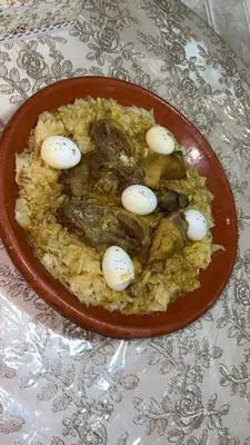 a plate of food with eggs on top of rice at Motel Ain Mersa in Ifrane