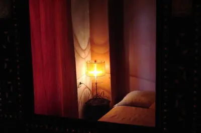 a room with a lamp and curtains in a mirror at Riad Tafilalet in Fès
