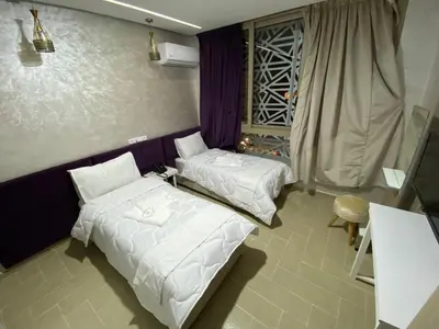 two beds in a room with white sheets and a window at HOTEL CHARk in Guercif