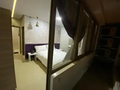 a bedroom with a white bed and a window at HOTEL CHARk in Guercif