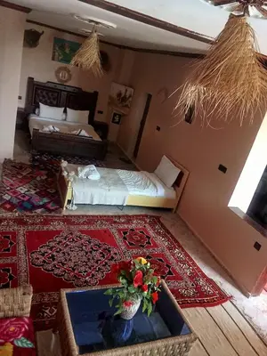 a hotel room with a bed and a bed and a room at kasbah amlal in Boumalne