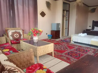 a living room with a couch and a table and a bed at kasbah amlal in Boumalne