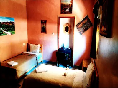 a small room with two beds and a mirror at kasbah amlal in Boumalne