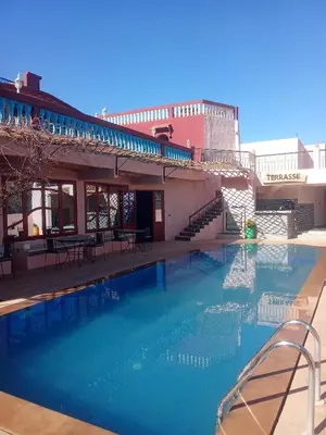 a large swimming pool in front of a building at kasbah amlal in Boumalne
