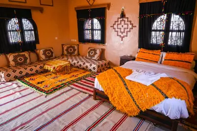 a bedroom with two beds and a couch at kasbah amlal in Boumalne