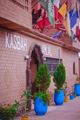 a brick building with potted plants in blue pots at kasbah amlal in Boumalne