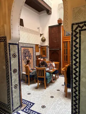 a group of people sitting at a table in a room at Dar Kenz Fes in Fès