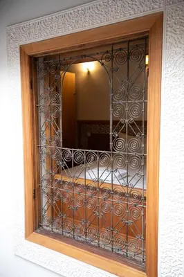 a window with a wooden frame and a mirror at Dar Kenz Fes in Fès