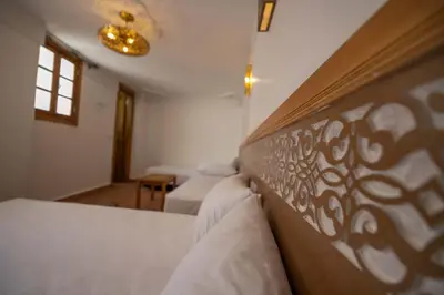 a bedroom with a bed with a wooden headboard at Dar Kenz Fes in Fès