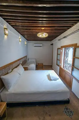 a bedroom with a large white bed and a window at Dar Kenz Fes in Fès