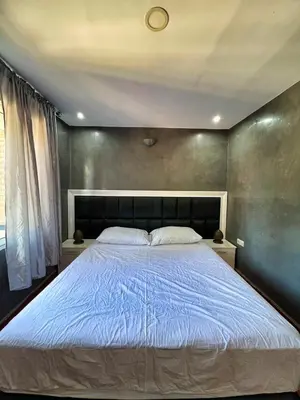 a bedroom with a large bed with blue sheets at Chalet Snow Valley - Private Pool in Imouzzer Kandar