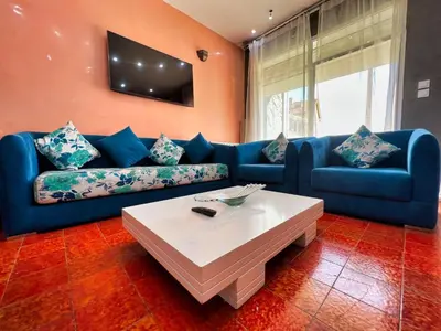 a living room with a blue couch and a table at Chalet Snow Valley - Private Pool in Imouzzer Kandar