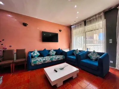 a living room with a blue couch and a table at Chalet Snow Valley - Private Pool in Imouzzer Kandar
