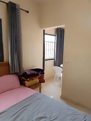a bedroom with a bed and a window and a chair at Hotel ASSAFIRE in Bou Mia