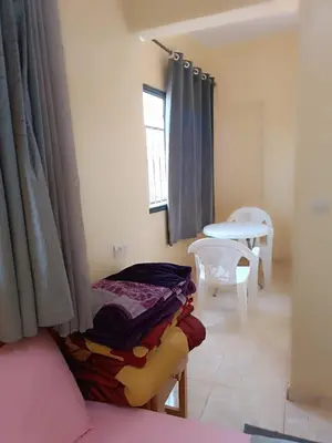 a room with a bed and a table and a window at Hotel ASSAFIRE in Bou Mia