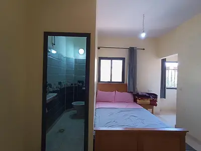 a bedroom with a bed and a bathroom with a shower at Hotel ASSAFIRE in Bou Mia