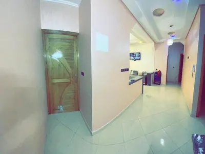 a hallway with a wooden door in a hospital at Dar Al Montazah in Meknès