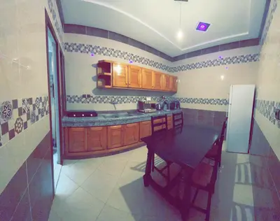 a kitchen with a table and a refrigerator at Dar Al Montazah in Meknès