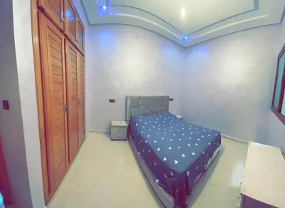 a bedroom with a bed and a wooden door at Dar Al Montazah in Meknès