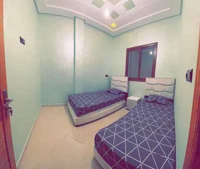 two beds in a room with purple beds in it at Dar Al Montazah in Meknès