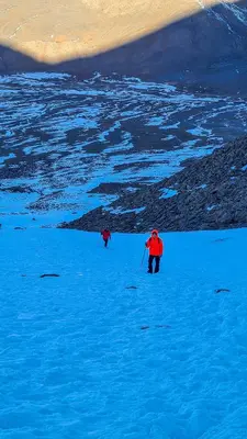 two people walking across a snow covered field at Eco-Lodge IGHAZRAN in Ahermoumou