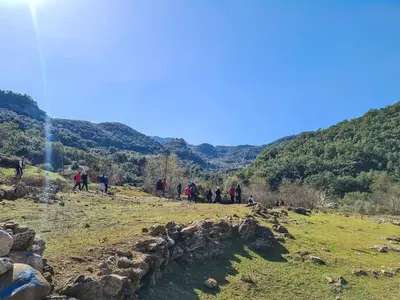 a group of people standing on a hill with a waterfall at Eco-Lodge IGHAZRAN in Ahermoumou