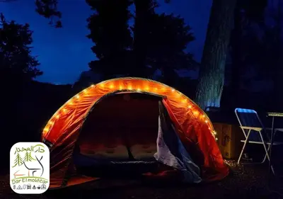 an orange tent with a chair in the dark at Eco-Lodge IGHAZRAN in Ahermoumou