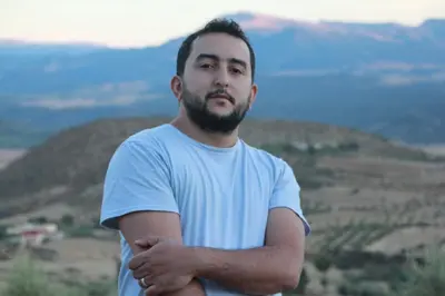 a man in a white shirt standing on a hill at Eco-Lodge IGHAZRAN in Ahermoumou