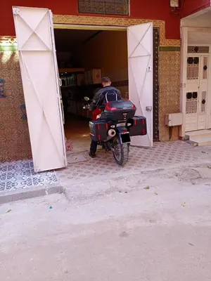 a motorcycle parked in a garage with a door open at Riad Mogador in Meknès