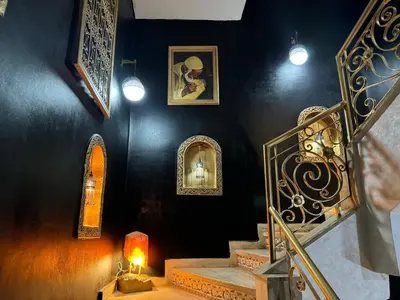 a room with a staircase with two windows and a lamp at Riad Mogador in Meknès