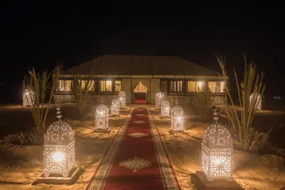 a building with lights in front of it at night at Sahara Events Camp in Merzouga