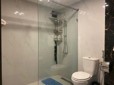 a bathroom with a toilet and a glass shower at Bloemen Huis in Fès