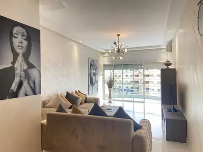 a living room with a couch and a painting of a woman at Bloemen Huis in Fès