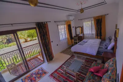 a bedroom with a bed and a balcony at Kasbah Roseville in Ait Sedrate Sahl Gharbia