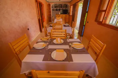 a dining room with a long table and chairs at Kasbah Roseville in Ait Sedrate Sahl Gharbia