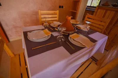 a table with a white table cloth and a tea kettle at Kasbah Roseville in Ait Sedrate Sahl Gharbia