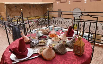 a table with plates of food on a red table cloth at Riad Parfums de OUARZAZATE in Ouarzazate