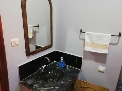 a bathroom with a sink and a mirror at Riad Ouinz in Aït Ben Haddou