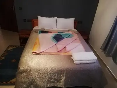 a bed with a pile of towels on it at Riad Ouinz in Aït Ben Haddou