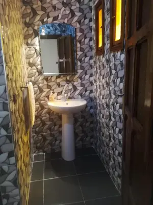 a bathroom with a sink and a mirror at Riad Ouinz in Aït Ben Haddou